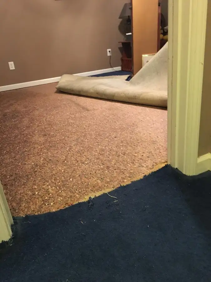 Carpet pad removal revealing water damage during Water Mitigation Services in Oconomowoc